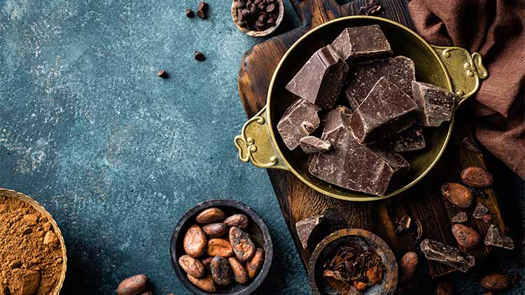 Dark chocolate pieces crushed and cocoa beans, culinary background, top view