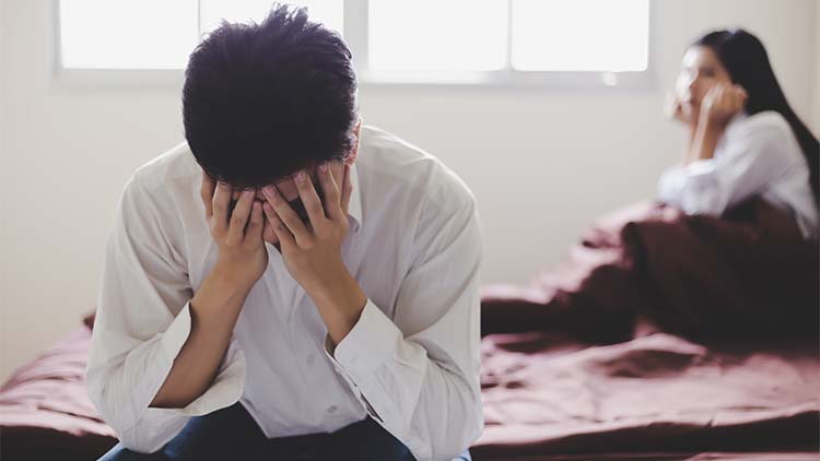 Handsome man get disappointed that his wife tell him for divorce because she get new boyfriend. Guy get shocked, sadness and unhappy. He use his hands to close his face with girlfriend background