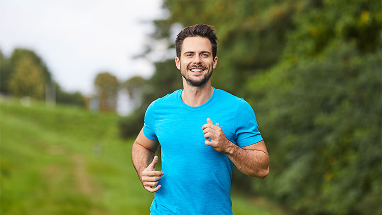 Happy man running in park during summer