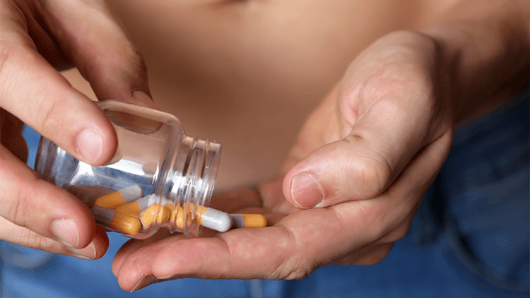 Man taking pills from a bottle