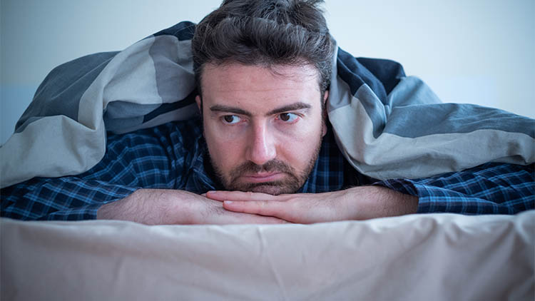 Man with sleep problem in his bed at home