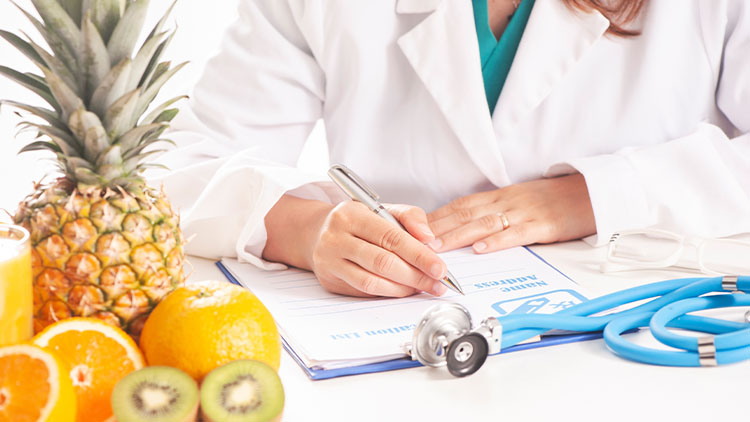 Nutritionist doctor writing diet plan on table.