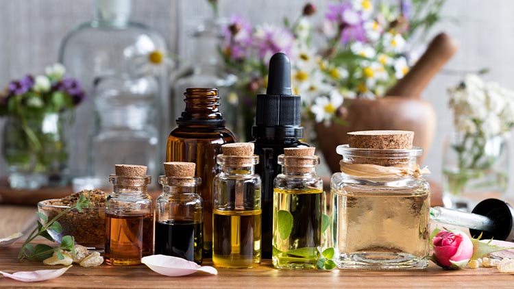 Selection of essential oils with herbs and flowers