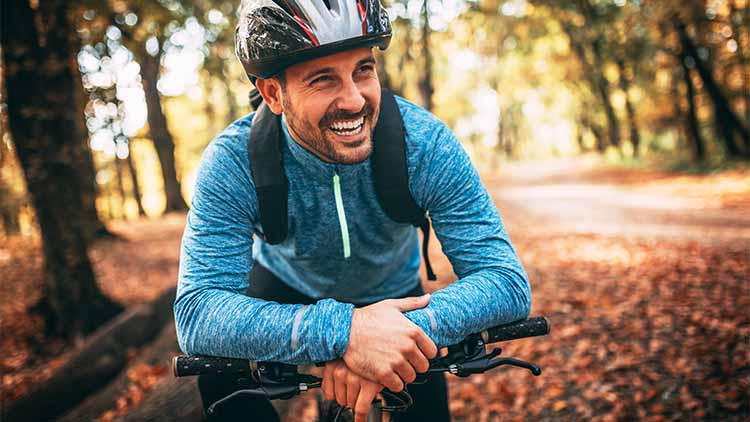 Young man biking through forest