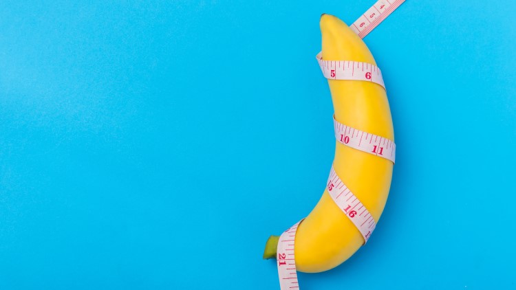 Banana with measurement tape wrapped around on blue background