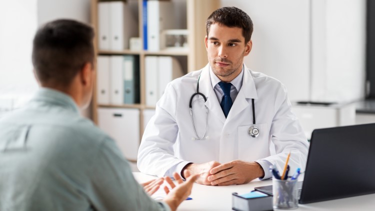 Doctor talking with male patient in medical office