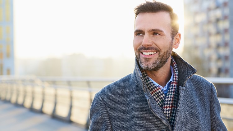 Happy man standing outdoors on sunny winter day