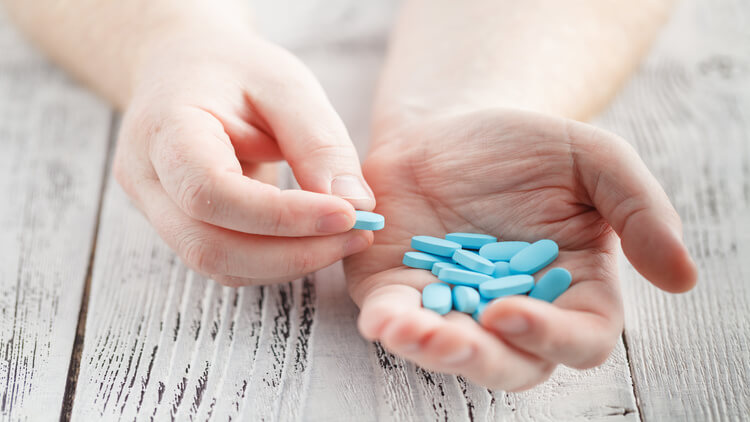 man holding blue pills