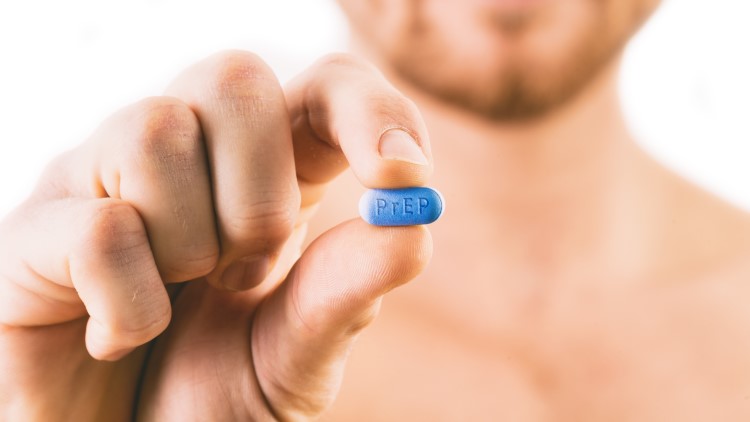 Man holding pill with prep written on pill