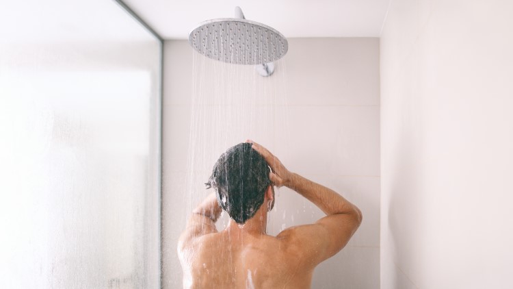 Man taking a shower rinsing hair