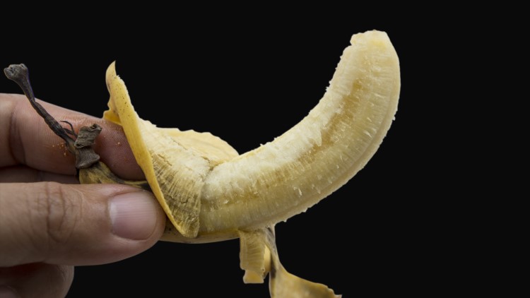 Peeled banana being carefully held