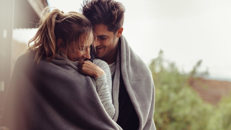 Romantic couple wrapped in blankets outdoors