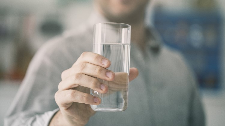 Smiling man holding glass of water