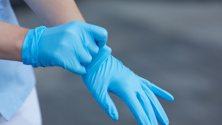 Doctor pulling on medical gloves