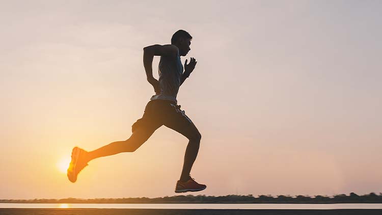 young man runner running on running road in city park