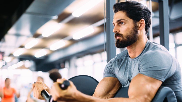 Young man sat exercising in gym